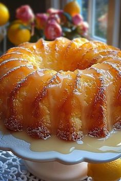 a bundt cake sitting on top of a white plate next to lemon wedges