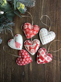 four heart shaped ornaments on a wooden table