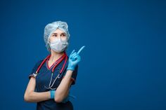 a female nurse in scrubs and gloves holding a scissors