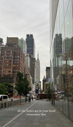 an empty city street with tall buildings and a quote written on the side of it