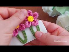 someone is crocheting flowers on a piece of paper