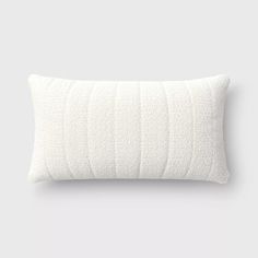 a white pillow with wavy lines on the front and back, against a gray background