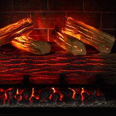 a fire burning in a brick fireplace with wood logs and bright red flames surrounding it