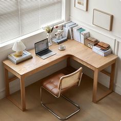 a wooden desk with a laptop computer sitting on top of it next to a window