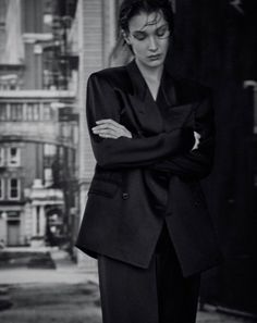 black and white photograph of a woman in a suit standing with her arms folded on her chest