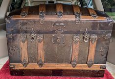 an old trunk sitting in the back of a car