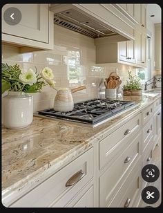 a kitchen with white cabinets and marble counter tops is seen on the appliance