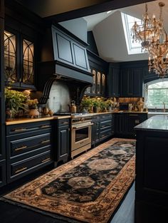 a large rug in the middle of a kitchen with black cabinets and an ornate chandelier