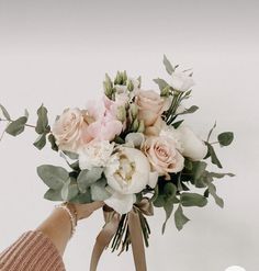 a woman holding a bouquet of flowers in her hand