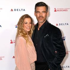 a man standing next to a woman on a red carpet