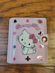 a pink hello kitty notebook on a wooden table