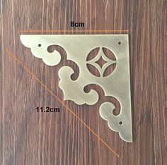 an image of a metal bracket on a wooden surface with measurements for the size and shape