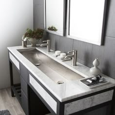 a bathroom with double sinks and mirrors on the wall