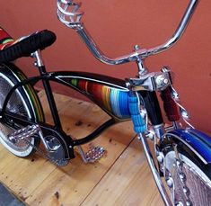 a colorful bicycle parked on top of a wooden floor