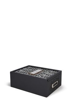 a black box with an intricate design on the lid and handles, sitting in front of a white background