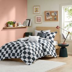 a black and white checkered comforter on a bed in a room with pink walls