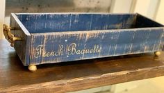 a wooden box with french writing on it sitting on top of a table next to a door