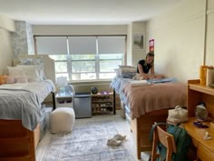 a woman sitting on top of a bed in a bedroom next to a desk and chair