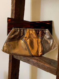 Offering an amazing, Snakeskin Patchwork Clutch Handbag, in gold, rose gold, silver & bronze. With zig zag top-stitching. Not labeled, but unmistakably Bags by Varon. With a pair of juxtaposed geometric triangular handles in a faux tortoise shell lucite that pulls open & snaps shut on a V-hinged frame. A fabulous vintage art accessory to wear. Circa 1960s. The bag is 6 inches high, including the lucite handles, and measures 9 3/4 inches along the bottom at its longest. The V-hinge is ful Patchwork Clutch, Men Mode, Hinged Frame, Mid Heel Shoes, Metallic Shoes, Hand Painted Leather, Tuxedo For Men, Art To Wear, Change Purse