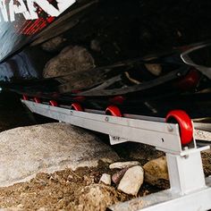 there is a boat sitting on the ground next to some rocks and gravel in front of it