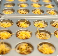 the muffin tins are filled with shredded cheese