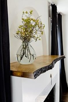 a vase filled with flowers sitting on top of a wooden shelf