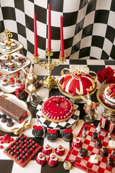 a table topped with cakes and desserts on top of a checkered table cloth