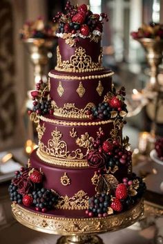 a red and gold wedding cake with berries on top