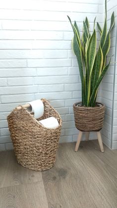 two wicker baskets holding toilet paper and a plant