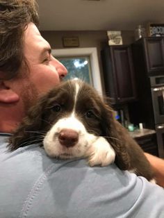 a man holding a puppy in his arms