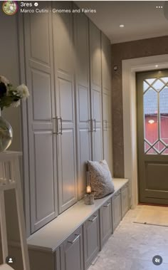 a room with some white cabinets and flowers on the window sill in front of it