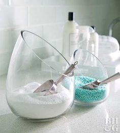 two bowls with scissors in them sitting on a counter next to blue and white powder