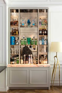 Painted gray bar display millwork with a mirror back and backlit onyx countertop. Glass Floating Shelves, Bar Shelf Ideas, Built In Bar Cabinet, Home Bar Rooms, Soho Loft, Bar Display, Bar Shelves, Stone Countertop