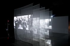 an image is projected on the wall behind sheer curtains