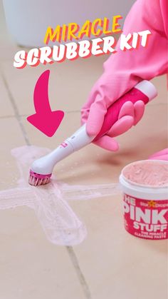 someone in pink gloves is cleaning the floor with a scrubber and toothpaste