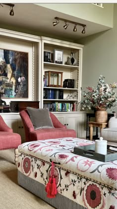 a living room with two couches and a coffee table in front of bookshelves