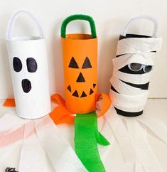 three toilet paper roll crafts with faces and pumpkins on them, one for halloween