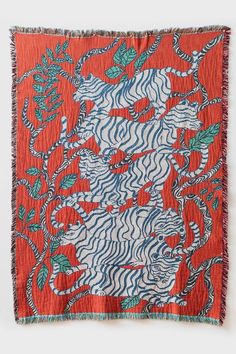 an orange and blue tapestry with zebras in the middle, on a white background