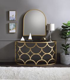 a mirror sitting on top of a table next to a vase and potted plant