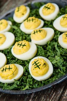 eggs are arranged in the shape of footballs on top of green leafy greens