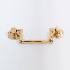 a gold toilet roll holder on a white wall