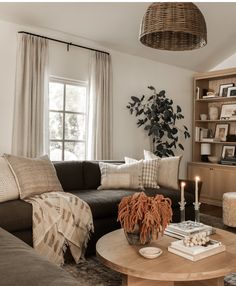 a living room with a couch, coffee table and bookshelf in front of a window