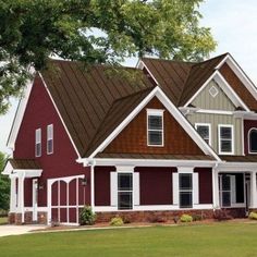 a red house with white trim and brown shingles