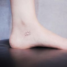 a small sun and cloud tattoo on the foot