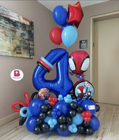 an inflatable balloon sculpture with spiderman and balloons on the top is displayed