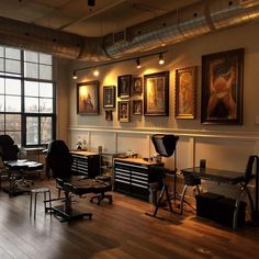 an office with lots of chairs and desks in front of large windows on the wall