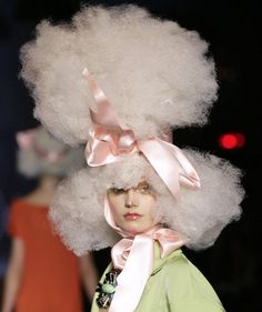 a woman with white hair wearing a wig and pink bow on top of her head