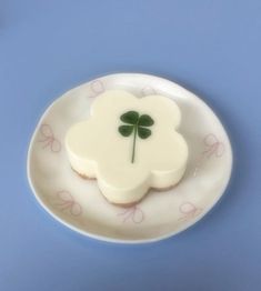 a white plate topped with two cookies covered in frosting and a clover shaped cookie