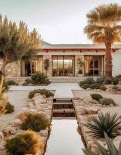 a house that is surrounded by trees and plants in front of the entrance to it