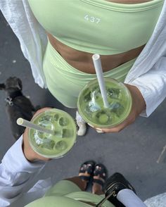 two people holding drinks with straws in their hands